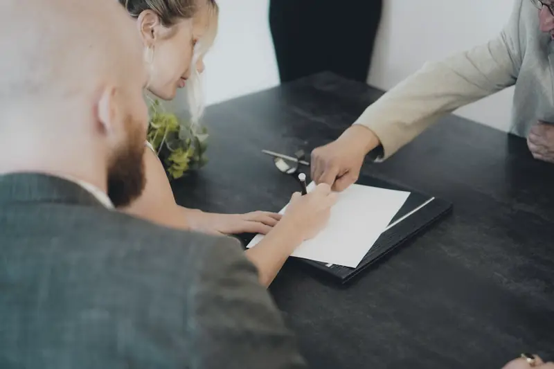 Couple reviewing and signing a document at a desk