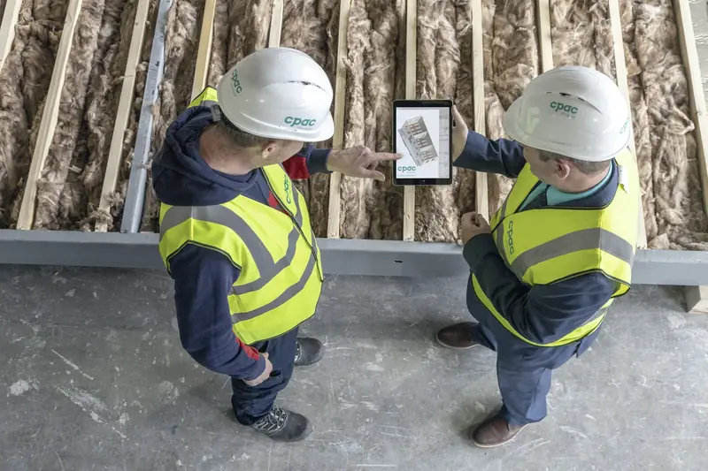 Two construction workers reviewing plans on a tablet